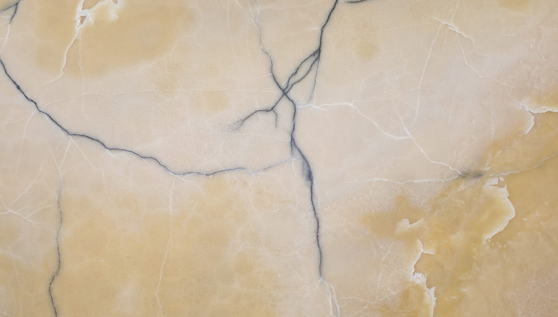 Close-up of beige marble texture with dark veins.