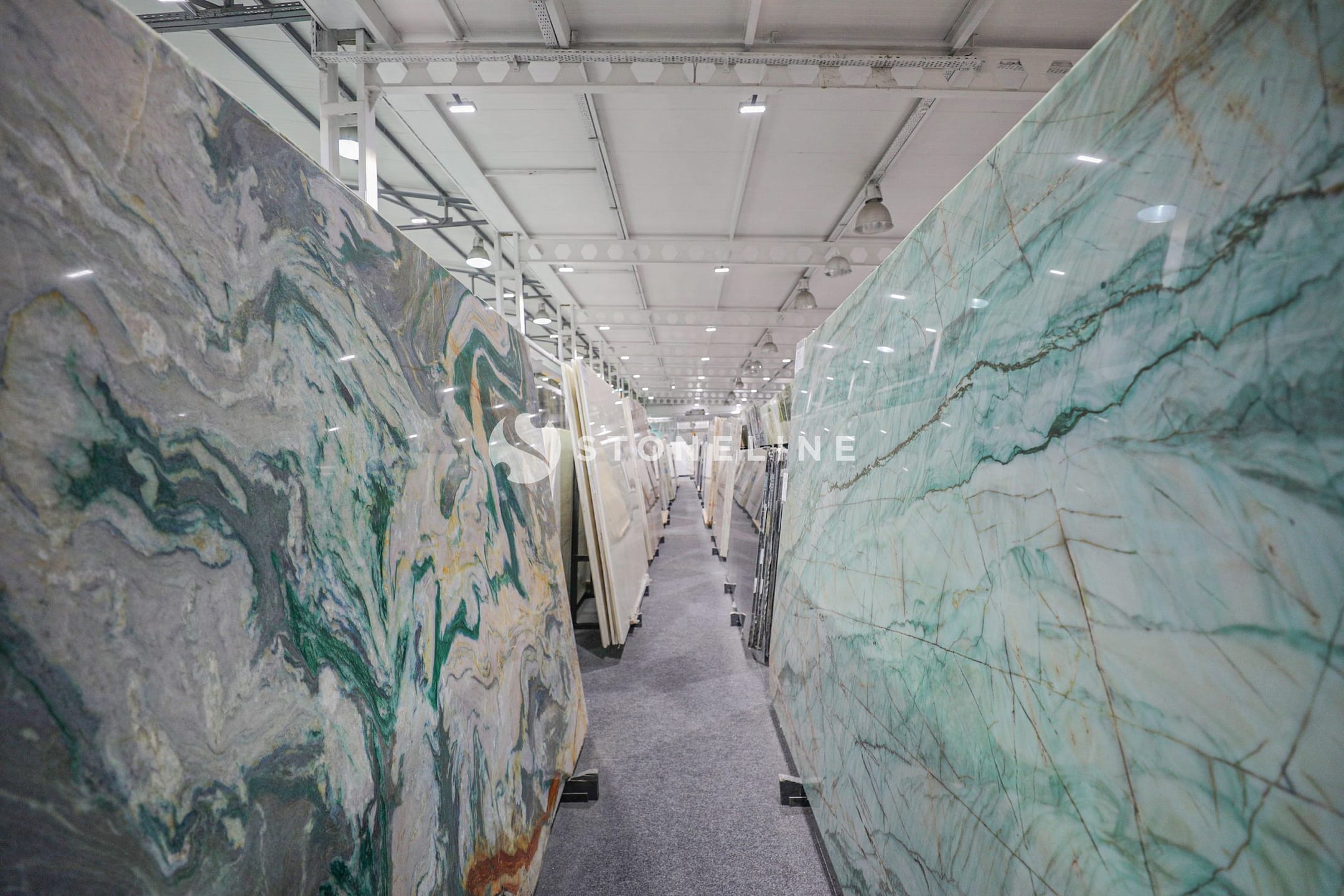 Marble slabs displayed in a warehouse aisle.