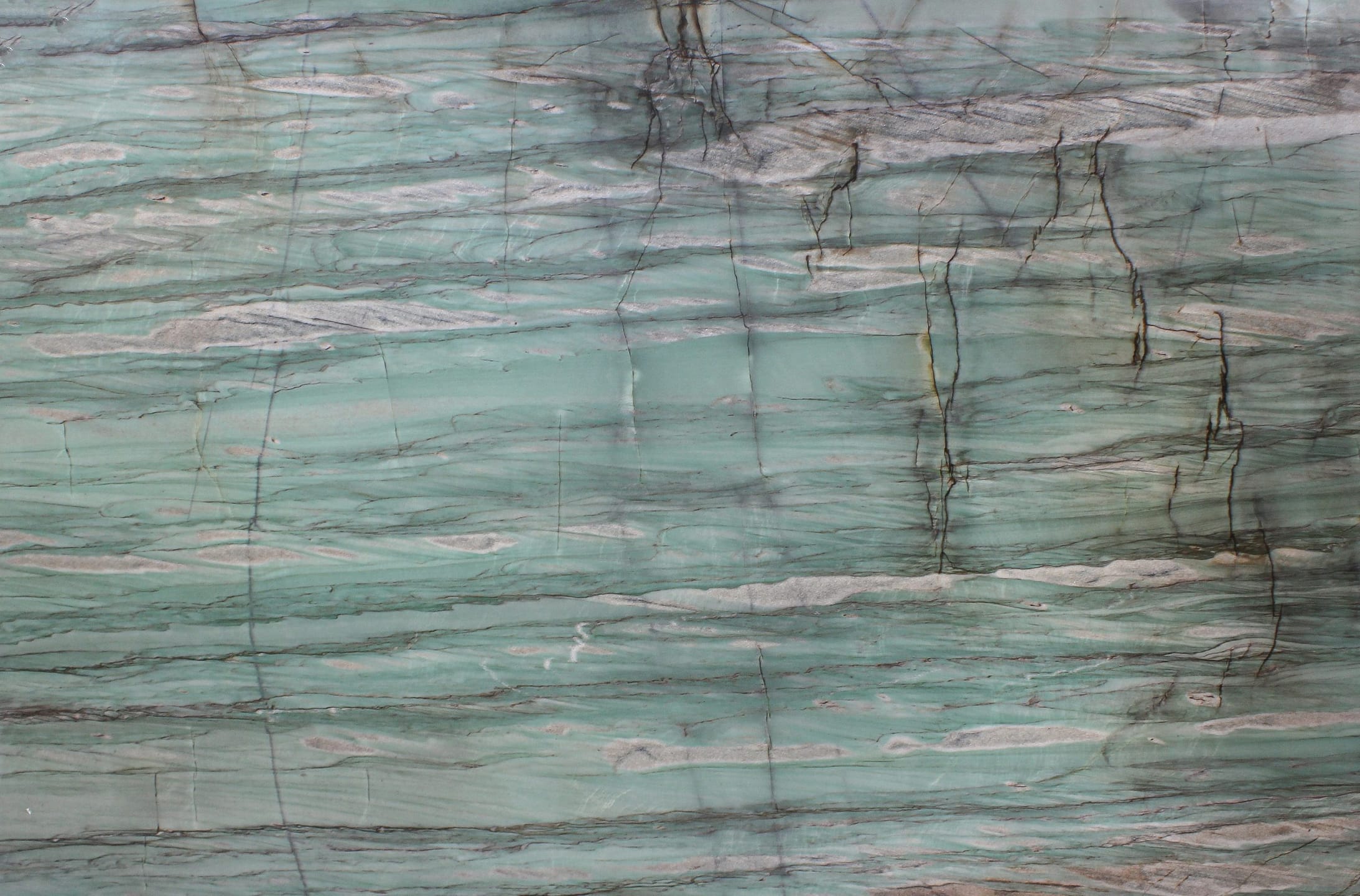 Close-up of marble surface with teal and gray veins.