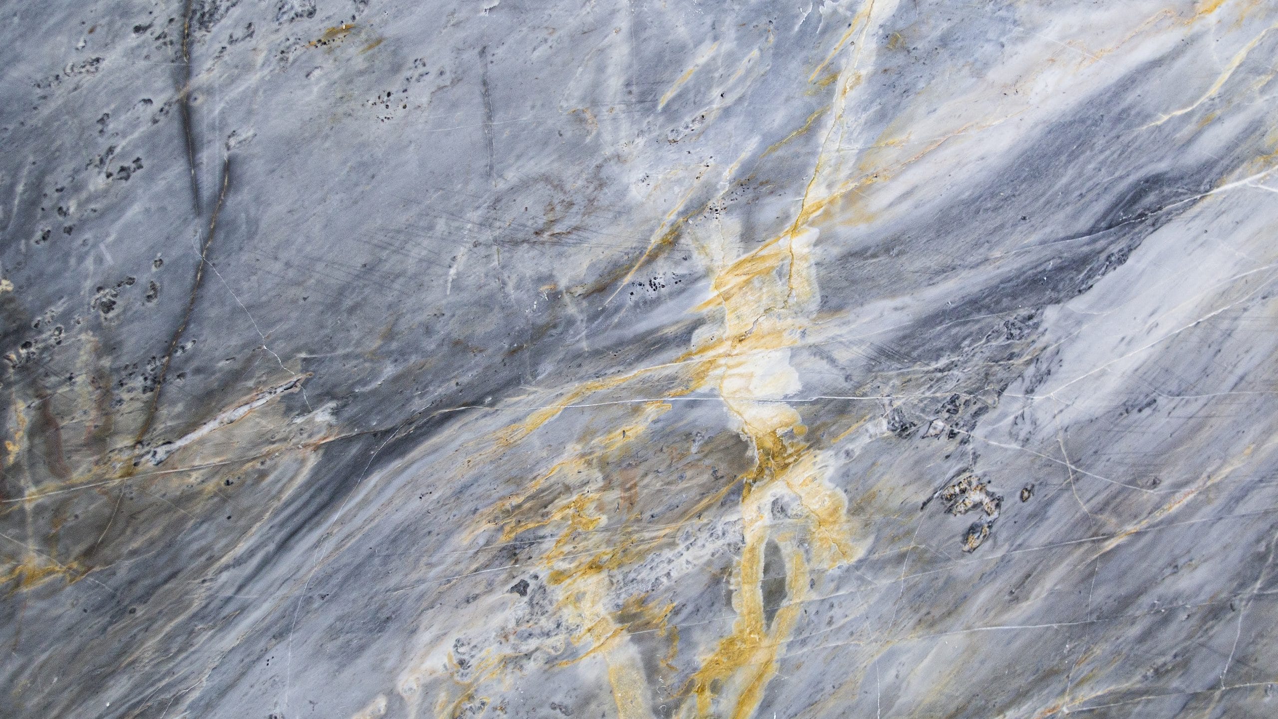 Close-up of textured gray and gold marble surface.