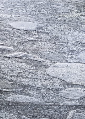 Gray textured stone surface with uneven patterns.