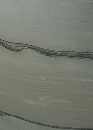 Close-up of textured stone surface with dark lines.