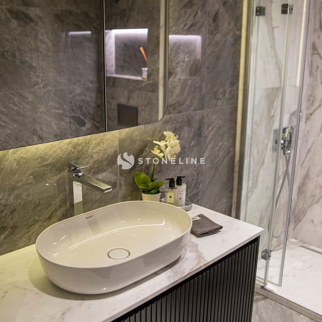 Modern bathroom with marble sink and shower.