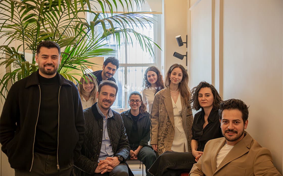 Group of people smiling in an office setting.
