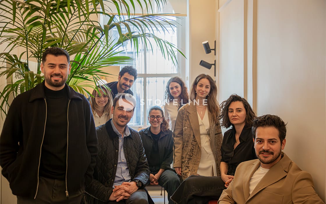 Group of people smiling in an office setting.