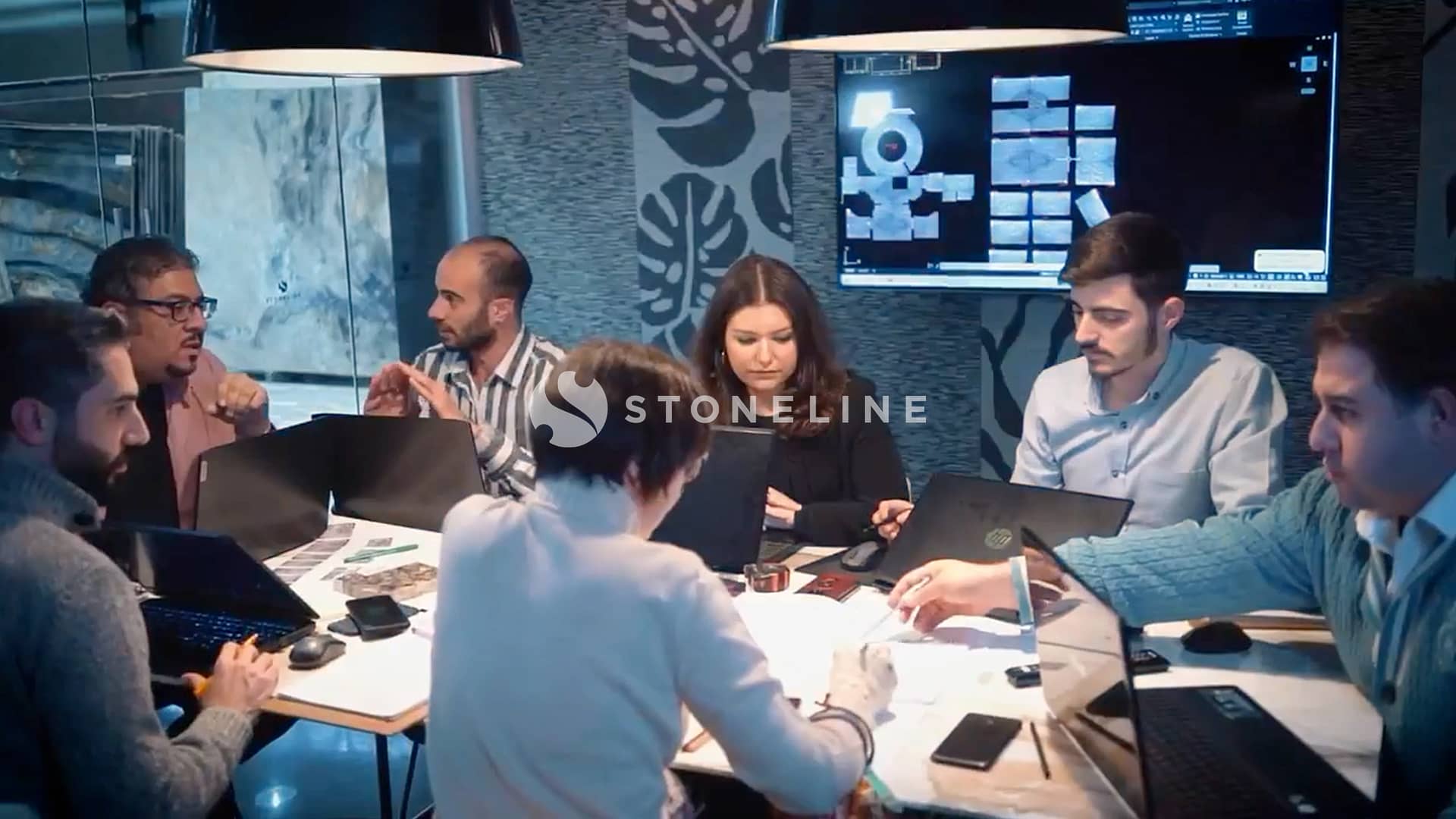 Team collaborating in modern meeting room with laptops.